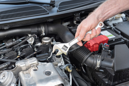 Hands of car mechanic repairing a car engineの写真素材