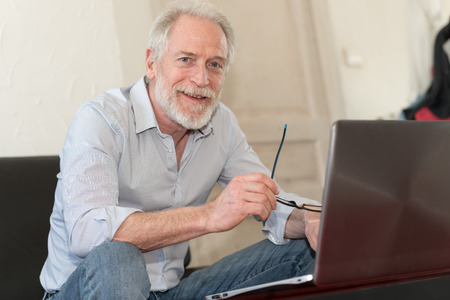 Modern mature man working on laptop at home