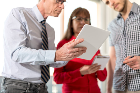 Business people in meeting working on tablet in officeの写真素材