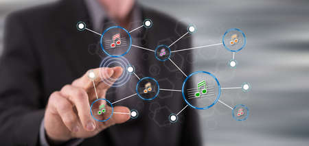 Man touching a music sharing network on a touch screen with his fingerの写真素材