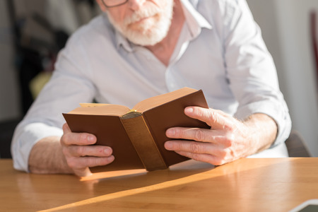 Mature man reading a book at home