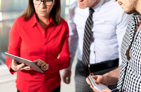 Business people in meeting working on tablet in office