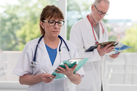 Portrait of female and male mature doctorsの写真素材