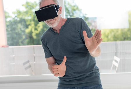 Senior man using a virtual reality headsetの写真素材