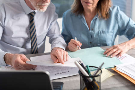 Two mature business people working together in officeの写真素材