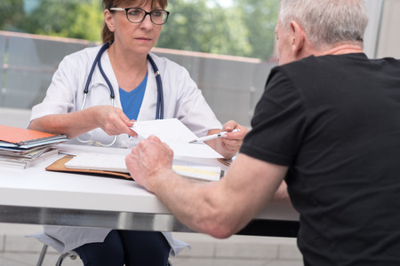 Female doctor giving prescription to her patient in medical officeの写真素材