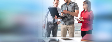 Business people in meeting working on laptop in office