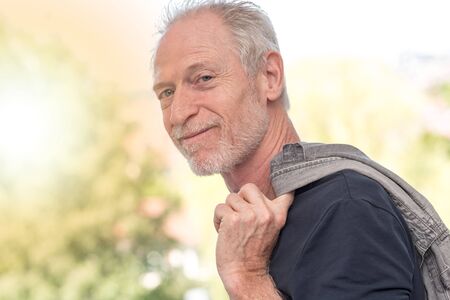 Portrait of satisfied mature man, light effect