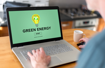 Man using a laptop with green energy concept on the screenの写真素材