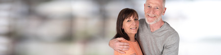 Happy senior couple embracing each other on blurred background