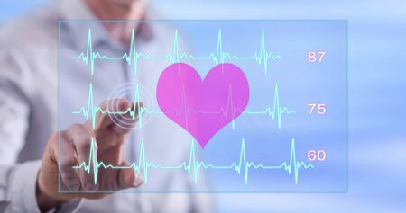Man touching a heart beats graph concept on a touch screen with his fingerの写真素材