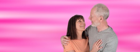 Happy senior couple embracing each other on blurred backgroundの写真素材
