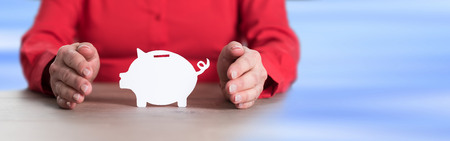 Piggy bank protected by handsの写真素材