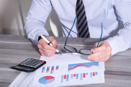 Accountant working on financial documents and using a calculator