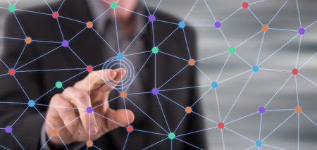 Man touching a virtual network on a touch screen with his fingerの写真素材