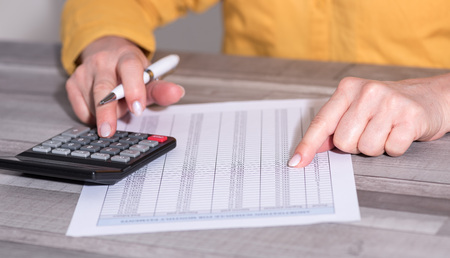 Hands of an accountant working on financial documents and using a calculator