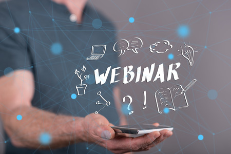 Webinar concept above a smartphone held by a man in backgroundの写真素材