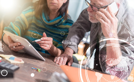 Senior business people working on tablet in office, double exposure, light effect