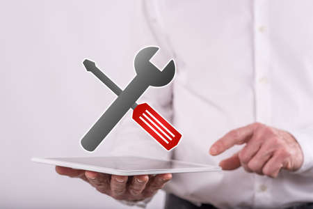 Maintenance service concept above a tablet held by a man in background