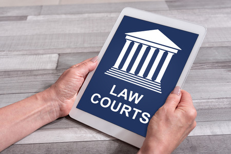 Female hands holding a tablet with law courts conceptの写真素材
