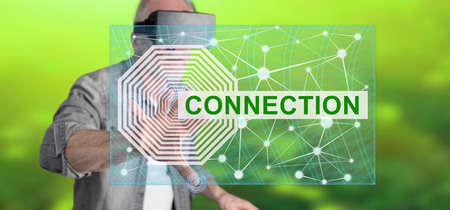 Man wearing a reality virtual headset touching a connection concept on a touch screen with his fingerの写真素材