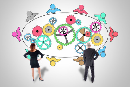 Teamwork concept drawn on a wall watched by business peopleの写真素材