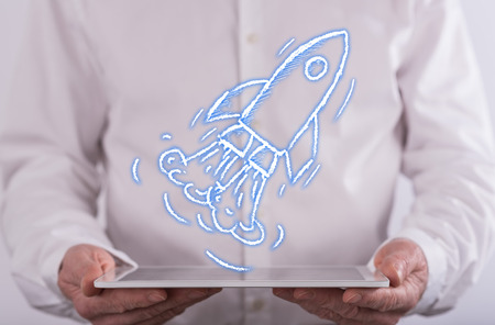 Start up concept above a tablet held by a man in background