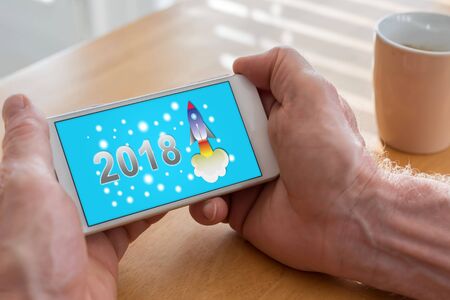 Male hands holding a smartphone with new year 2018 conceptの写真素材