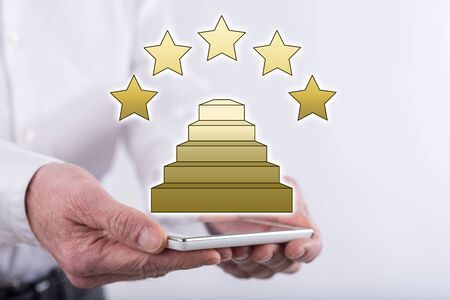 Quality concept above a smartphone held by handsの写真素材