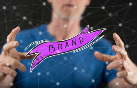 Brand concept between hands of a man in backgroundの写真素材