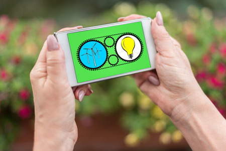 Female hands holding a smartphone with clean energy concept