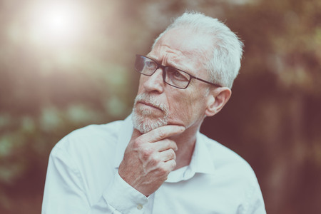 Portrait of thoughtful mature man outdoors, light effect