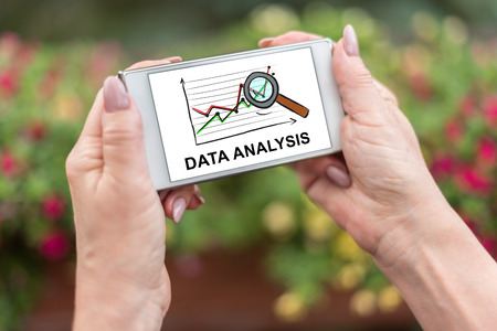Female hands holding a smartphone with data analysis conceptの写真素材