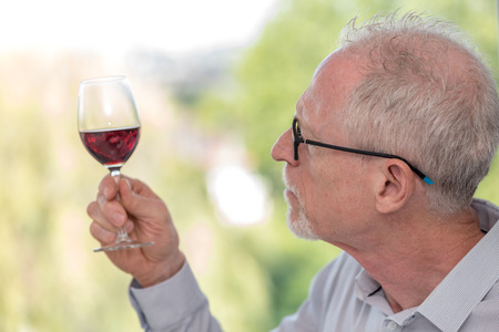 Senior man tasting red wine