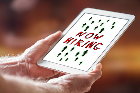 Man holding a tablet showing hiring conceptの写真素材