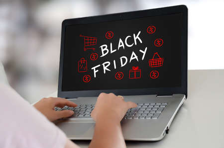 Woman using a laptop with black friday concept on the screenの写真素材