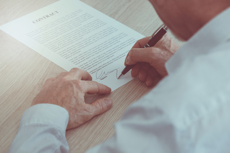 Man signing a legal documentの写真素材