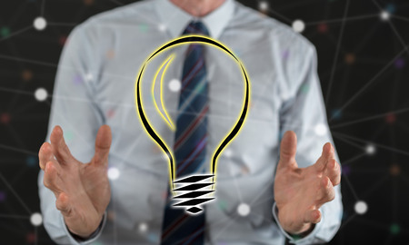Bright idea concept between hands of a man in backgroundの写真素材