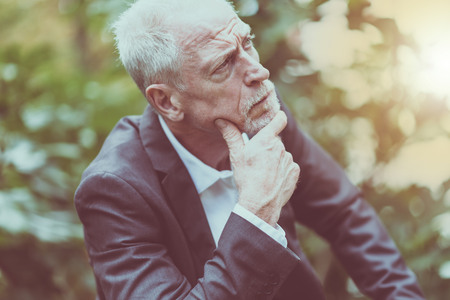 Portrait of thoughtful mature man outdoors, light effectの写真素材