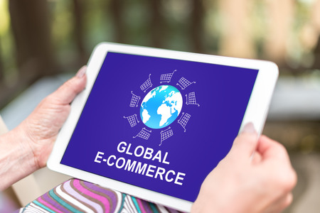 Female hands holding a tablet with global e-commerce concept