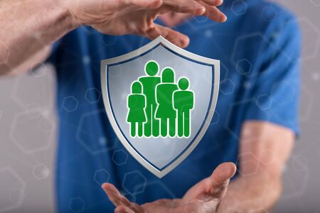 Family protection concept between hands of a man in backgroundの写真素材