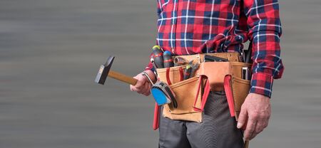 Building worker with tool belt on blurred backgroundの写真素材