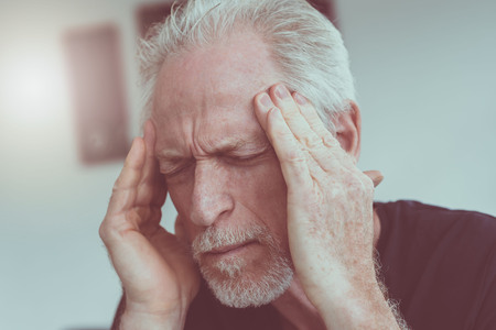 Mature man having a headache at homeの写真素材