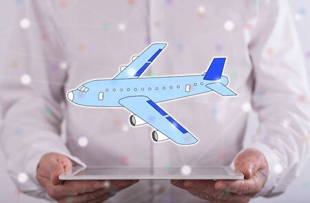 Air transport concept above a tablet held by a man in backgroundの写真素材