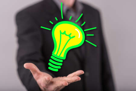 Green energy concept above the hand of a man in backgroundの写真素材