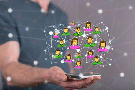 Social network concept above a smartphone held by a man in backgroundの写真素材
