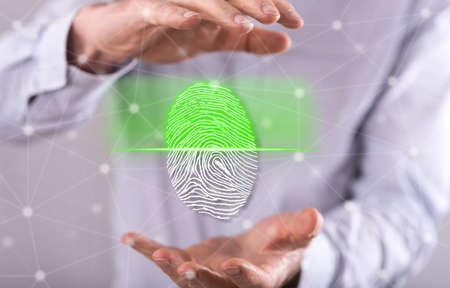 Fingerprint security system concept between hands of a man in backgroundの写真素材
