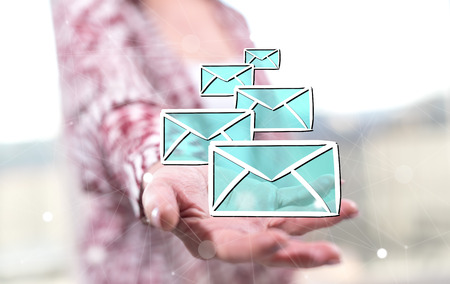 E-mail concept above the hand of a woman in backgroundの写真素材