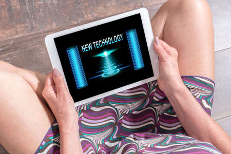 Woman sitting on the floor with a tablet showing new technology conceptの写真素材