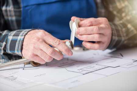 Plumber's hands putting  tape on a thread of a plumbing fitting